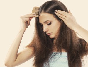 A young woman with beautiful long hair combing her locks